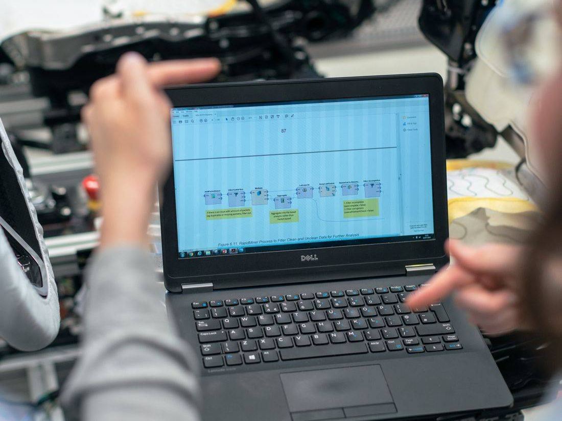 Engineer analysing machinery data on a laptop